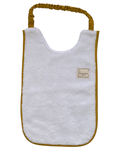 Babero SAVAGE LINE de rizo de bambú blanco con ribete y elástico color mostaza para bebés de 6 a 12 meses
