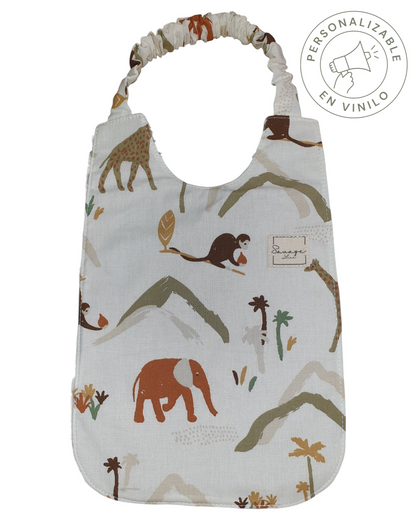 Babero Montessori SAVAGE LINE de algodón orgánico con estampado de jungla, elástico ajustable y reverso de bambú.