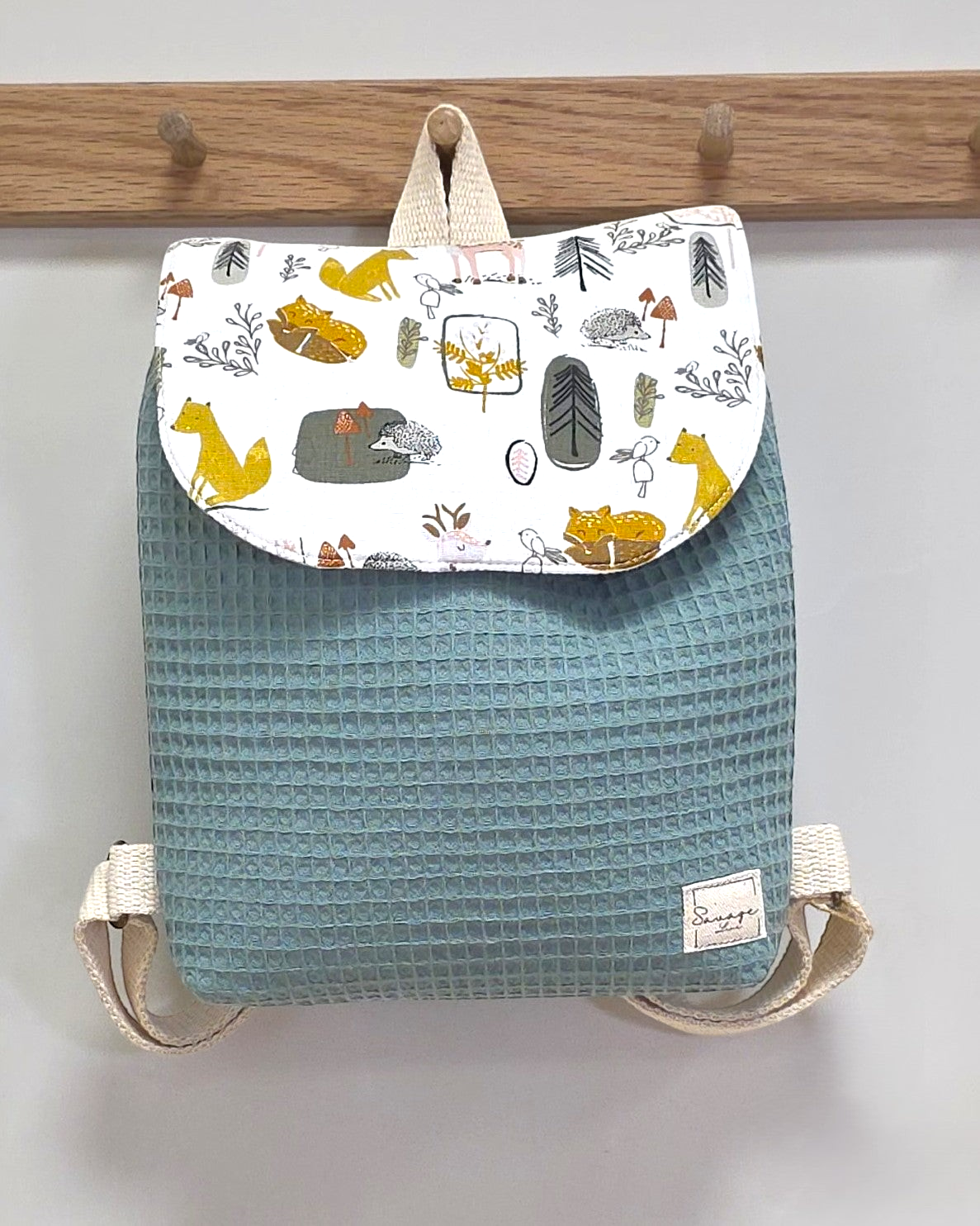 Mochila infantil SAVAGE LINE Candy en tejido waffle verde con solapa estampada de bosque y correas ajustables.