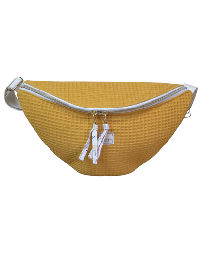 Riñonera artesanal SAVAGE LINE modelo Chloe en tejido waffle color mostaza con cremallera blanca y correa ajustable