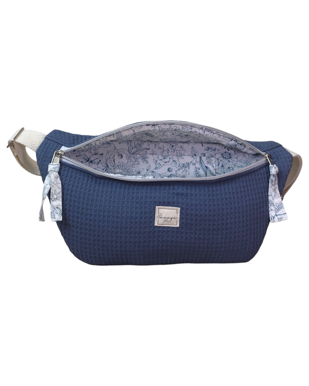 Riñonera artesanal SAVAGE LINE modelo Micka en tejido waffle azul con forro interior estampado floral y correa