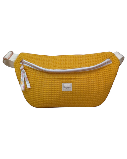 Riñonera artesanal SAVAGE LINE modelo Micka en tejido waffle color mostaza con correa ajustable y cremallera blanca.